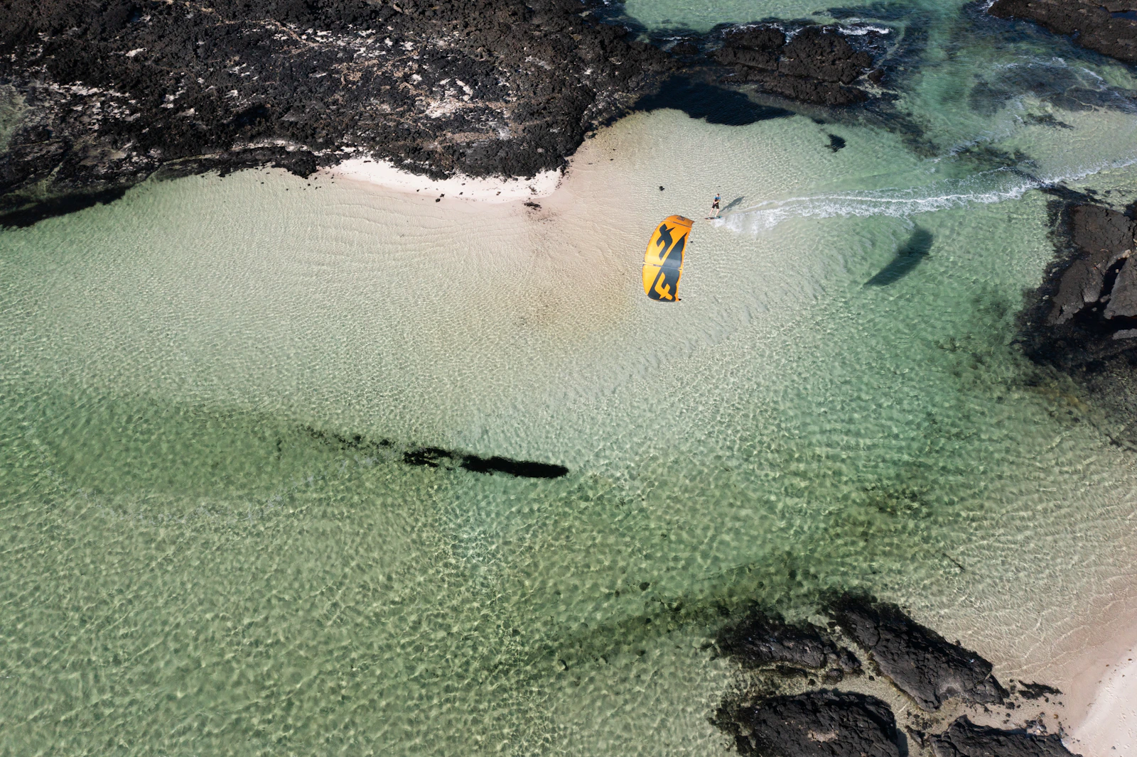 Cometa amarilla junto a una playa vista desde el aire