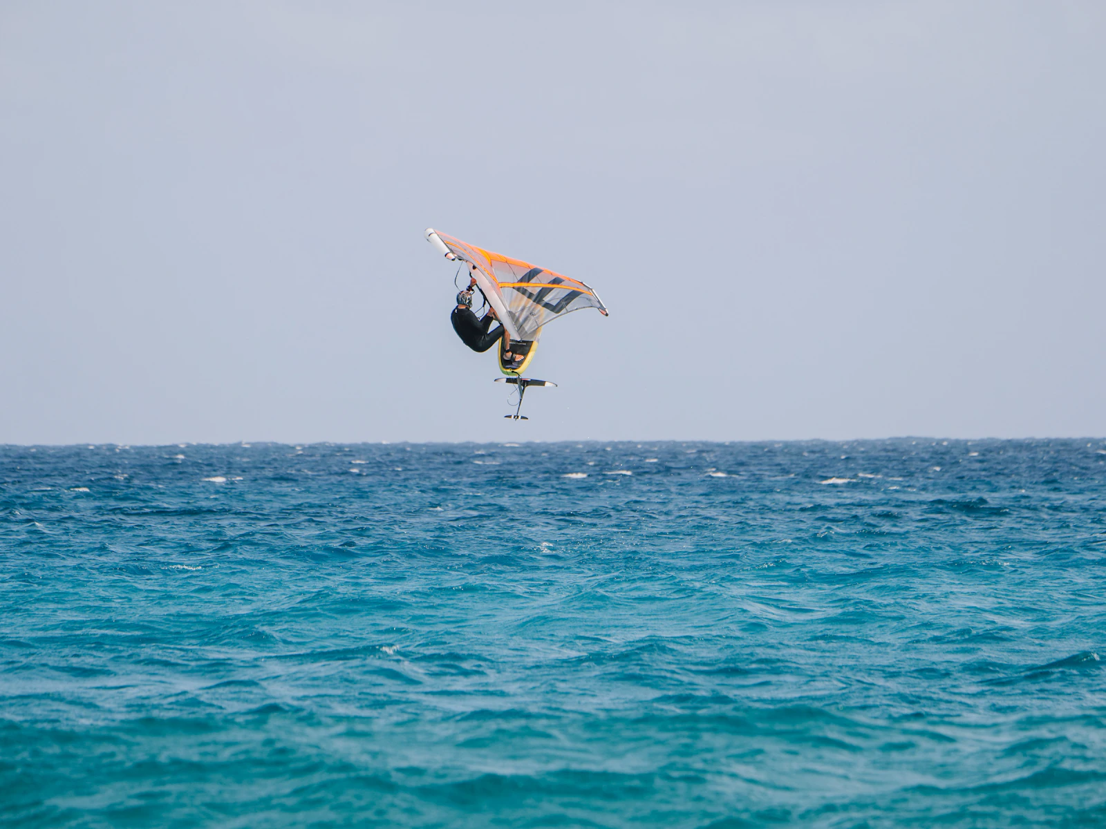 Navegante de wingfoil saltando sobre el mar